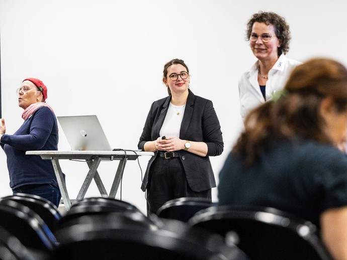Zwei Frauen halten einen Vortrag, während eine Gebärdendolmetscherin am Rand übersetzt. (vergrößerte Bildansicht wird geöffnet)