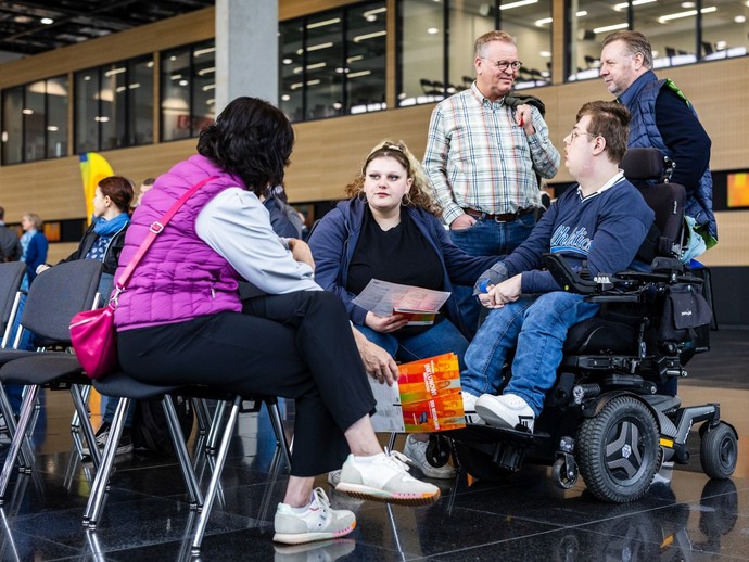 Fünf Personen stehen im Foyer in einem Kreis und unterhalten sich. (vergrößerte Bildansicht wird geöffnet)