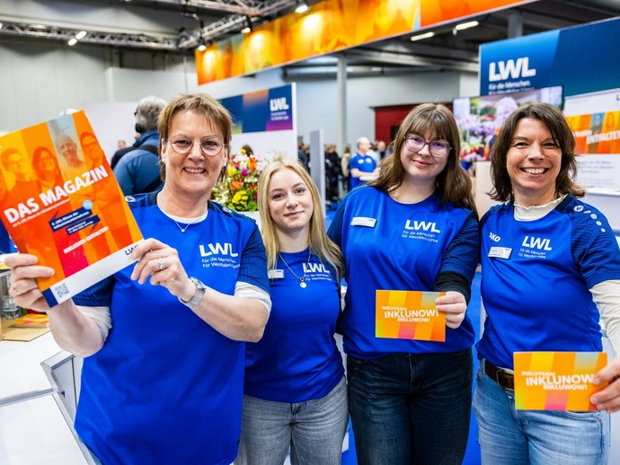 Vier Frauen aus dem Organisationsteam stehen nebeneinander, lächeln in die Kamera und halten Informationsmaterial in den Händen. (vergrößerte Bildansicht wird geöffnet)