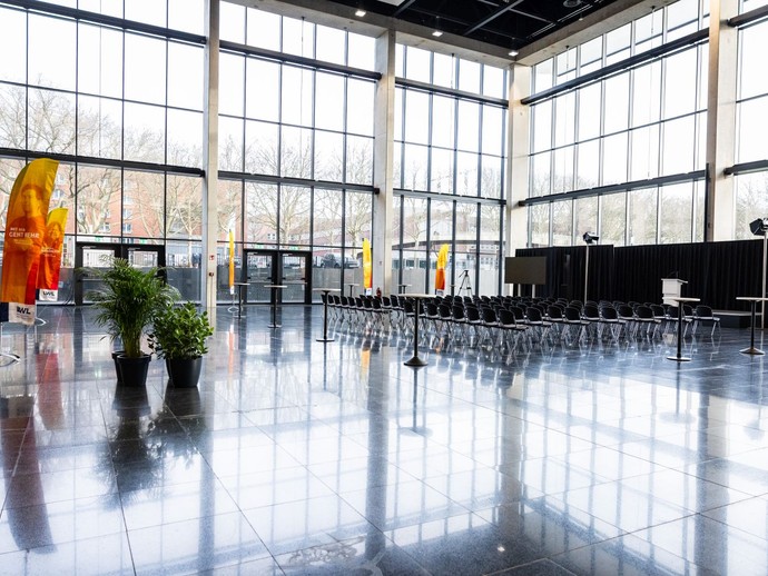 Leeres Foyer der Halle 5 mit in Reihen aufgestellten Stühlen vor Beginn der Eröffnungsveranstaltung. (vergrößerte Bildansicht wird geöffnet)