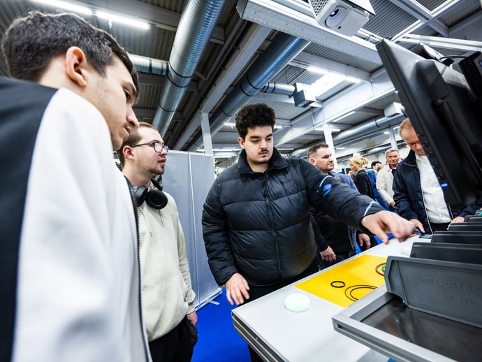 Drei junge Männer schauen aufmerksam auf einen Bildschirm. (vergrößerte Bildansicht wird geöffnet)