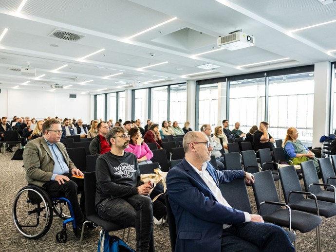 Viele Personen sitzen in einem Seminarraum und hören einem Fachvortrag zu. (vergrößerte Bildansicht wird geöffnet)